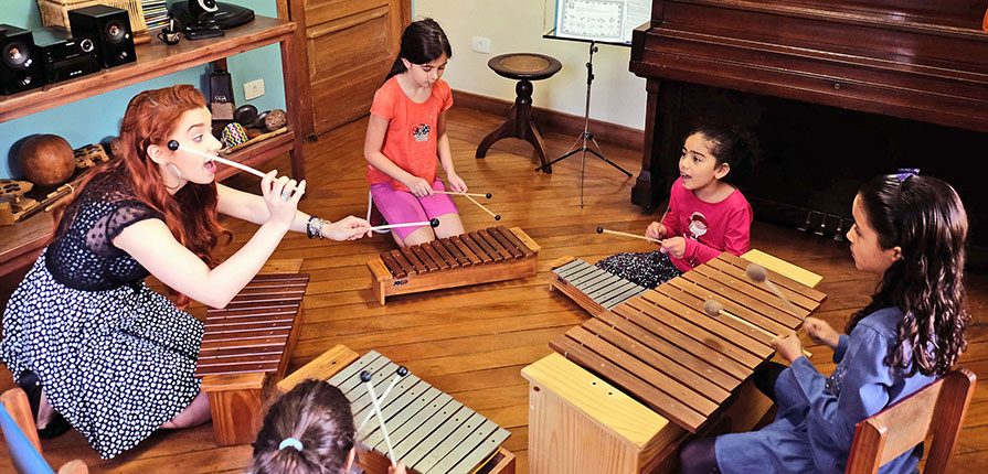 Professora de musicalização infantil praticando atividades com crianças