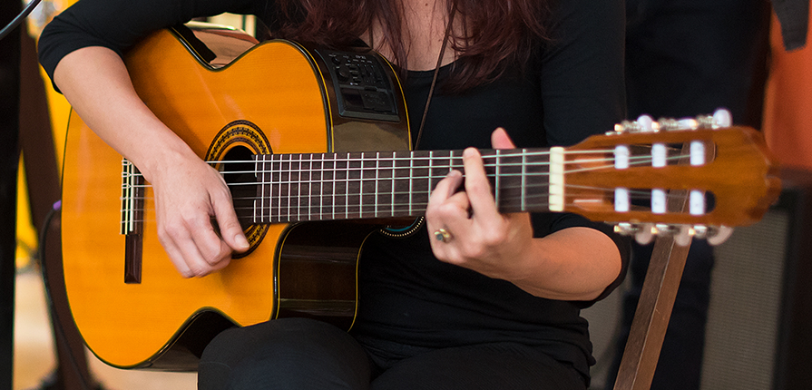 Aluna da escola de música praticando aulas de violão