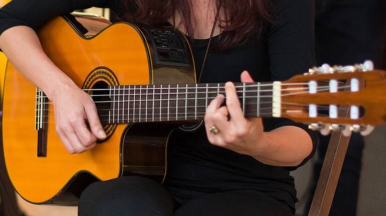 Aluna da escola de música, praticando aulas de violão